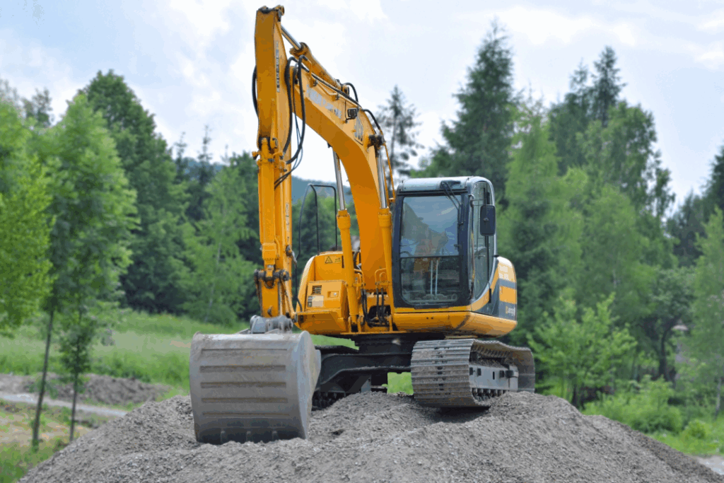 A yellow road roller drives on a road, performing road maintenance by compacting the surface as it progresses